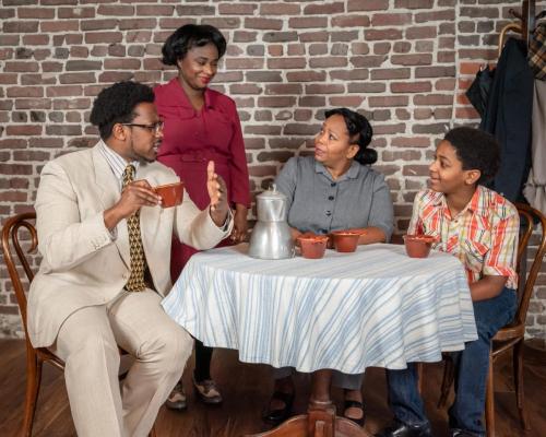 The Younger family sits around the dinner table. Left to right: Arlando Smith, Deja Culver, Marlette Buchanan, and Ajani Dickerson in A Raisin in the Sun at Taproot Theatre. Photo by Robert Wade.